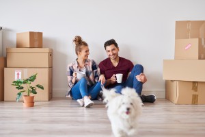 Woman and man with dog in a room with moving boxes