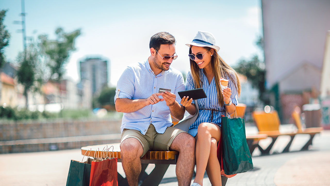 Young couple on park bench making an online purchase