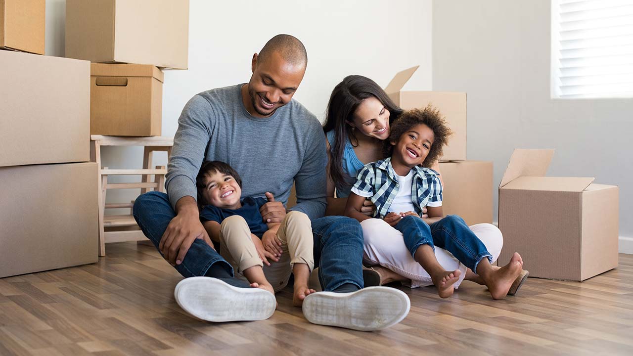 Mother, father and children sitting on the floor in their new home