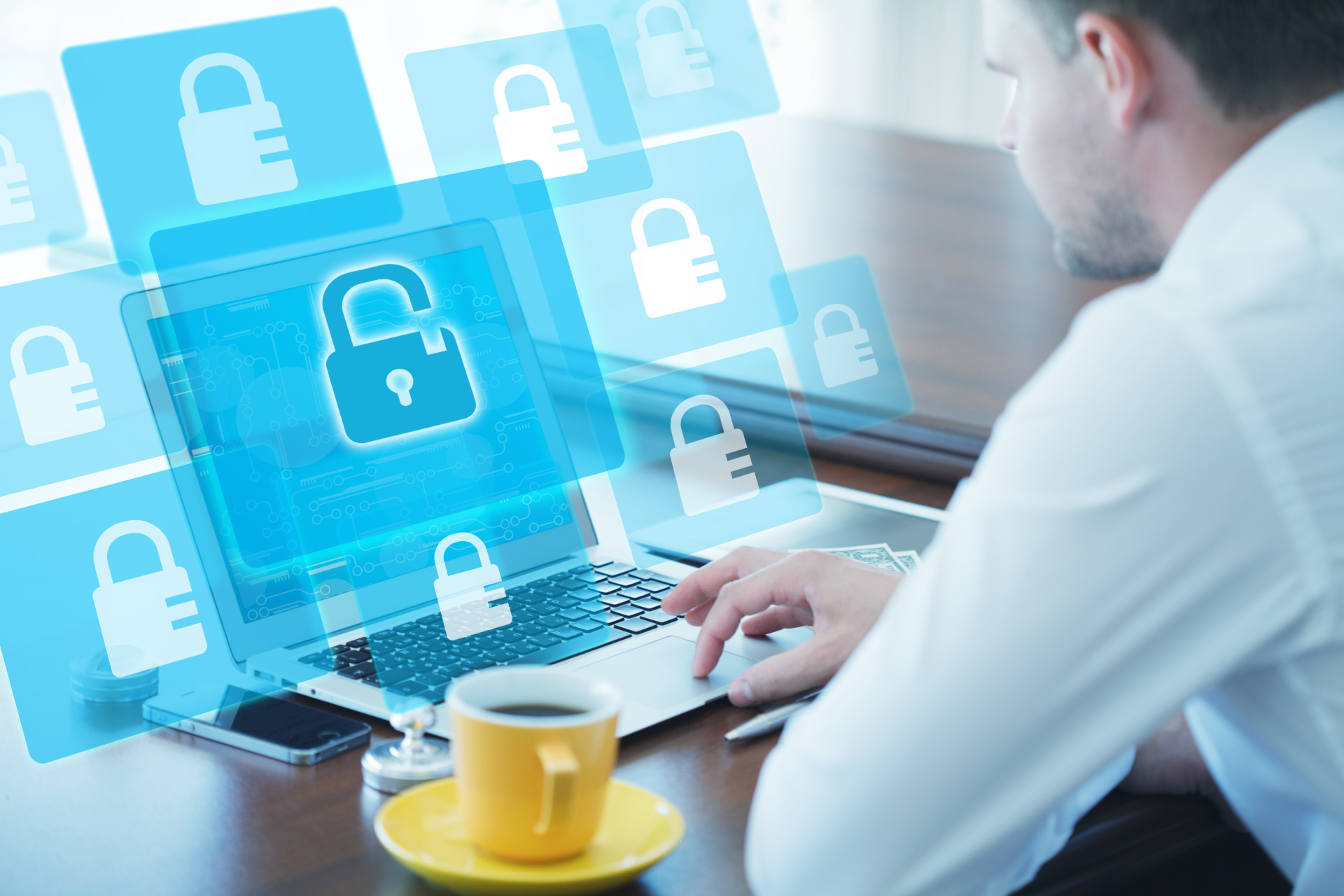 Man sitting at computer showing many screens with security locks.